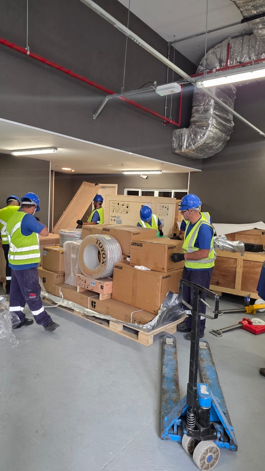 Equipe da TBI desembalando acessórios e componentes no local de instalação